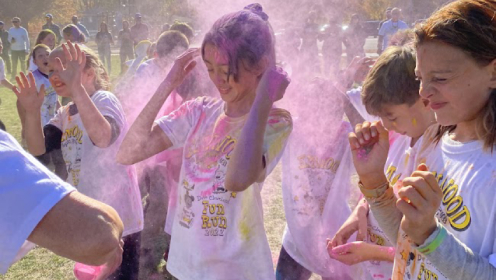 Students participating in the Elmwood Elementary Color Run, with pink colored dust in the air